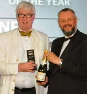 Paul Rowen receives his award and champagne from Howard Johnston, Editor-in-Chief of Tramways & Urban Transit.