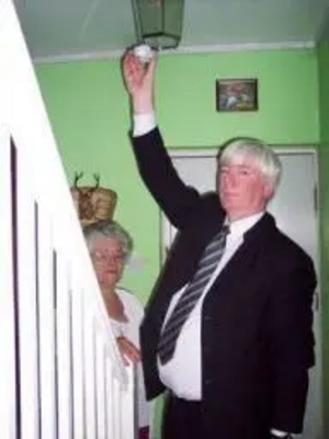 Paul fits a smoke alarm at the home of Rochdale pensioner Joyce Haynes.