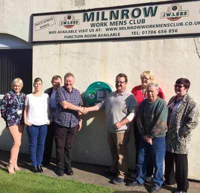 Lisa Kimpton (RMBC), Emma Lees, Andy Lees (Club Steward) Steve Lowe (Chairman of the Club), Councillor Irene Davidson, Club Stalwart Vic and Councillor Janet Emsley launch the defibrillator outside Milnrow Worker's Club